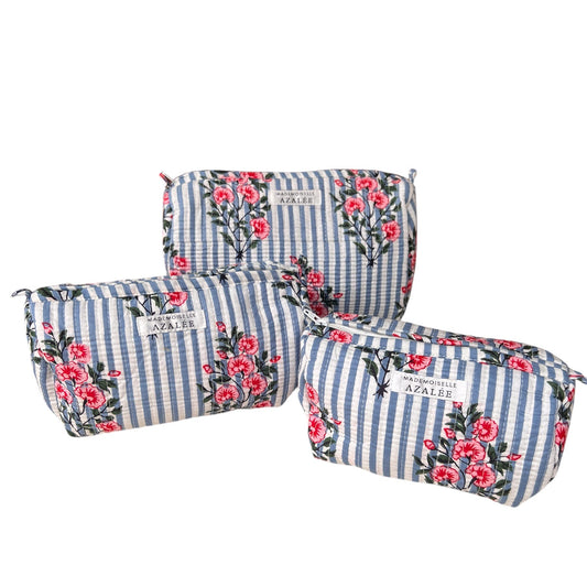 Trousse de toilette Peonie Blue en coton indien matelassé, motif fleuri rose sur rayures bleues et blanches, disponible en trois tailles.