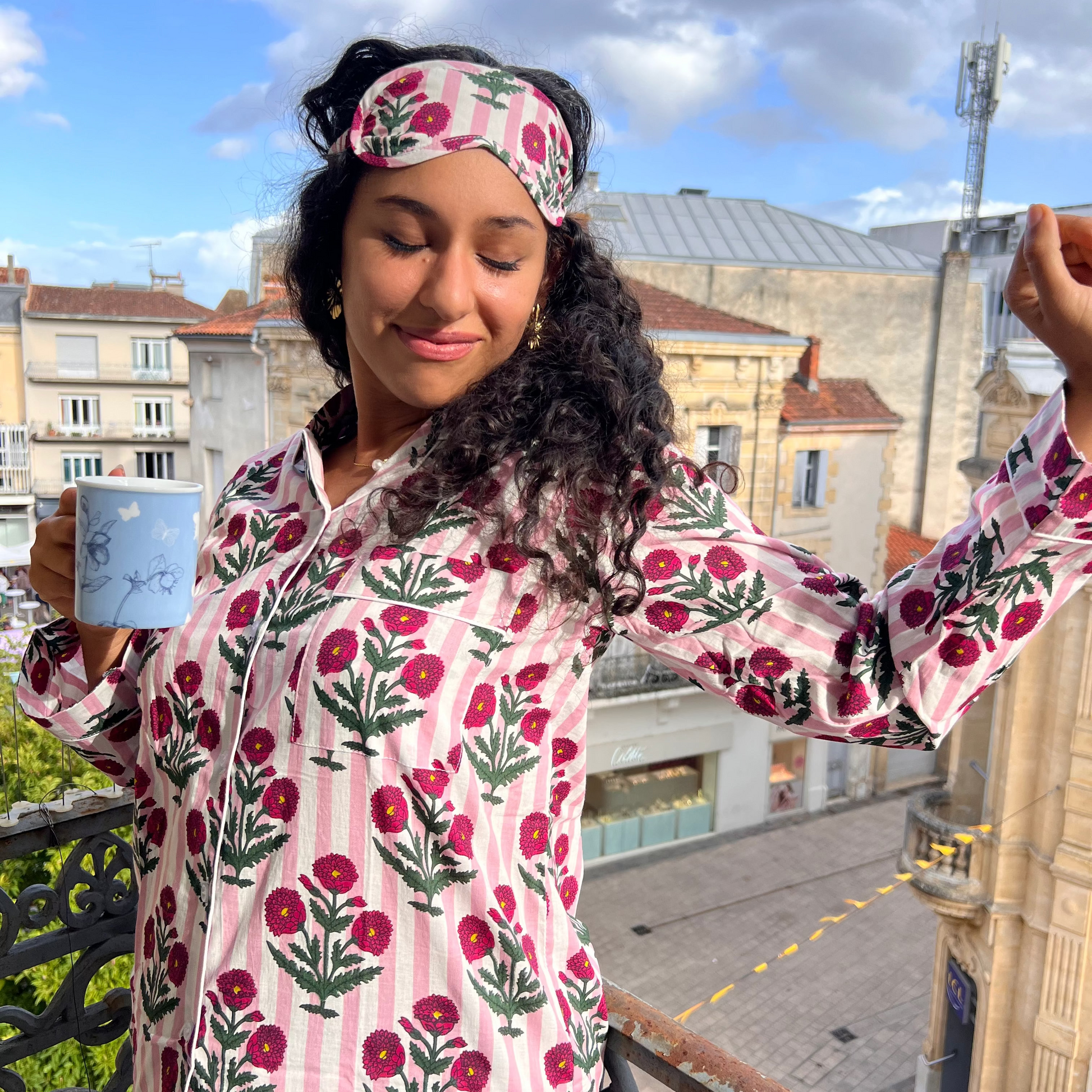 Jeune femme portant un pyjama long en coton indien avec des rayures roses et un imprimé floral rose à manches longues