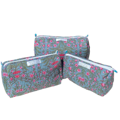 Trousse de toilette Butterfly en coton matelassé, imprimé floral rose et vert sur fond bleu-gris, disponible en trois tailles. 
