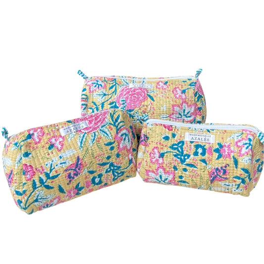 Kit de 3 trousses de toilette Suna en coton matelassé, imprimé floral rose et bleu sur fond jaune solaire, trois tailles assorties. 