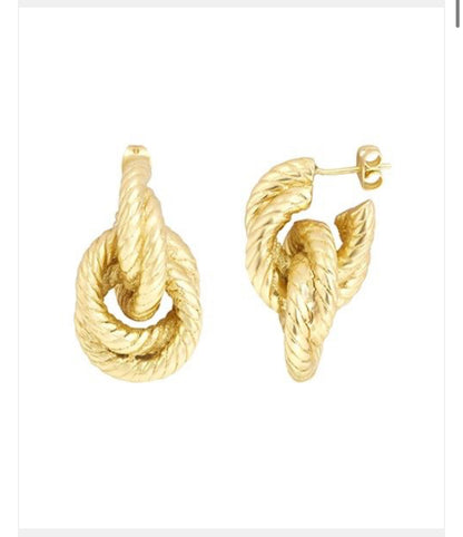 Boucles d’oreilles dorées Dear Charlotte en forme de nœud torsadé, présentées de côté sur fond blanc.
