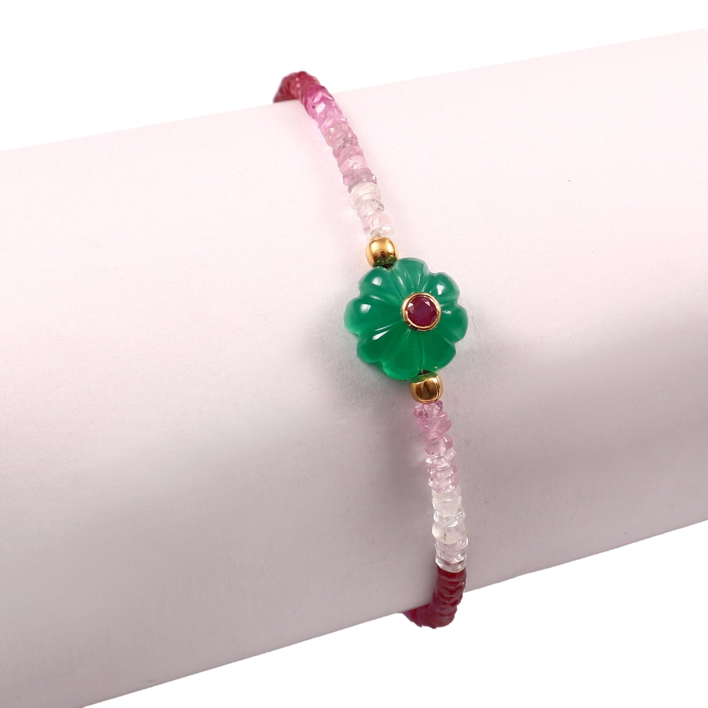 Bracelet Amara en perles de tourmaline rose avec fleur en onyx vert ornée d’un rubis, présenté porté en détail