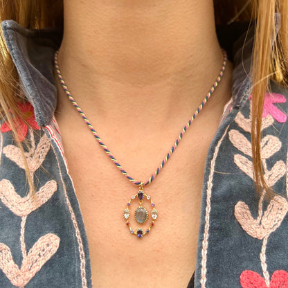 Collier Goa porté, avec pendentif en labradorite entouré de pierres fines multicolores montées sur apprêts plaqué or, suspendu à un cordon torsadé.