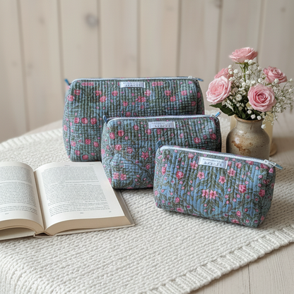 Kit de trousses de toilette City Palace en coton matelassé gris à motifs floraux roses, ensemble fait main présenté sur une table avec un livre ouvert et un bouquet de roses, création Mademoiselle Azalée à Agen 
