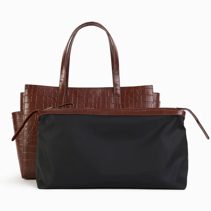 Sac Dakota Nat & Nin en cuir croco acajou avec sa pochette intérieure zippée noire sortie et présentée devant le sac.